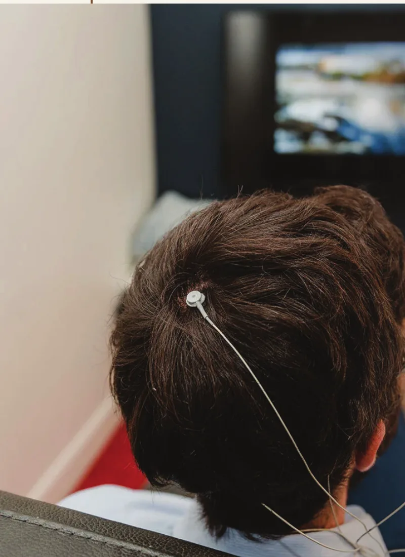 A client watching real-time visual feedback with a scalp sensor in place